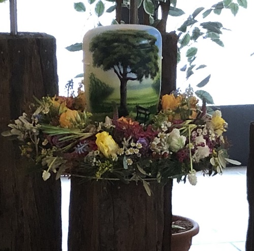 Urne mit Baum als Dekor, umgeben von einem Blumenkranz